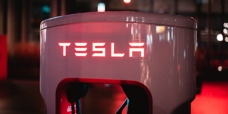 a red tesla logo on a white machine